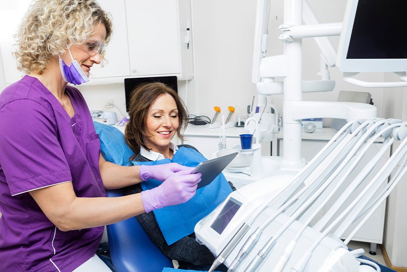 dental patient smiling with hygienist in exam chair